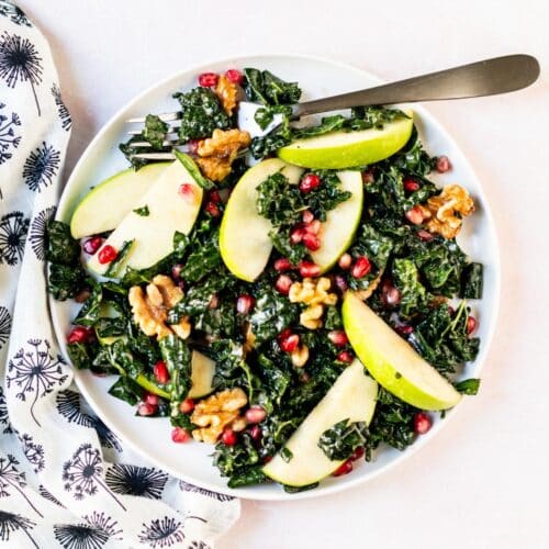 Kale salad with green apples, pomegranate seeds, and walnuts.